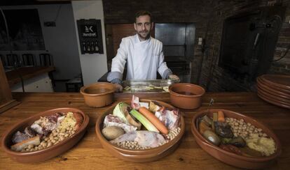 Cocinero de KANDRAK junto a las cazuelas de cocido y el horno