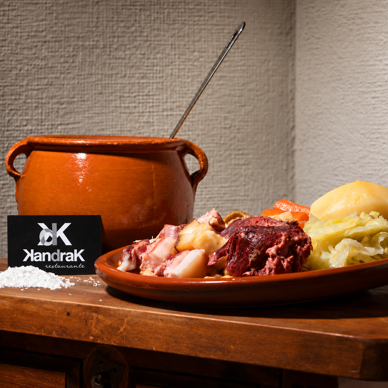 Cocido de KANDRAK servido en fuente de barro junto a su olla