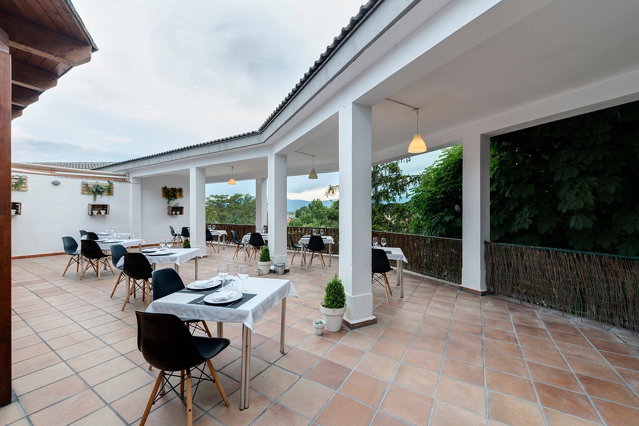 Terraza de KANDRAK con mesas preparadas y vistas hacia la sierra